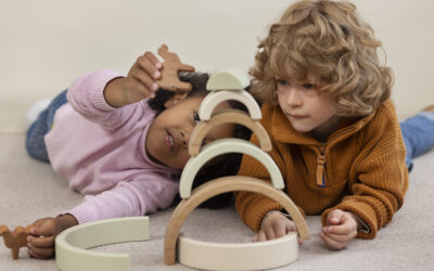 Happy Kids Boutique kinderen spelen samen met houten speelgoed en bouwen een toren met bogen, creatief spel met oog voor duurzaamheid