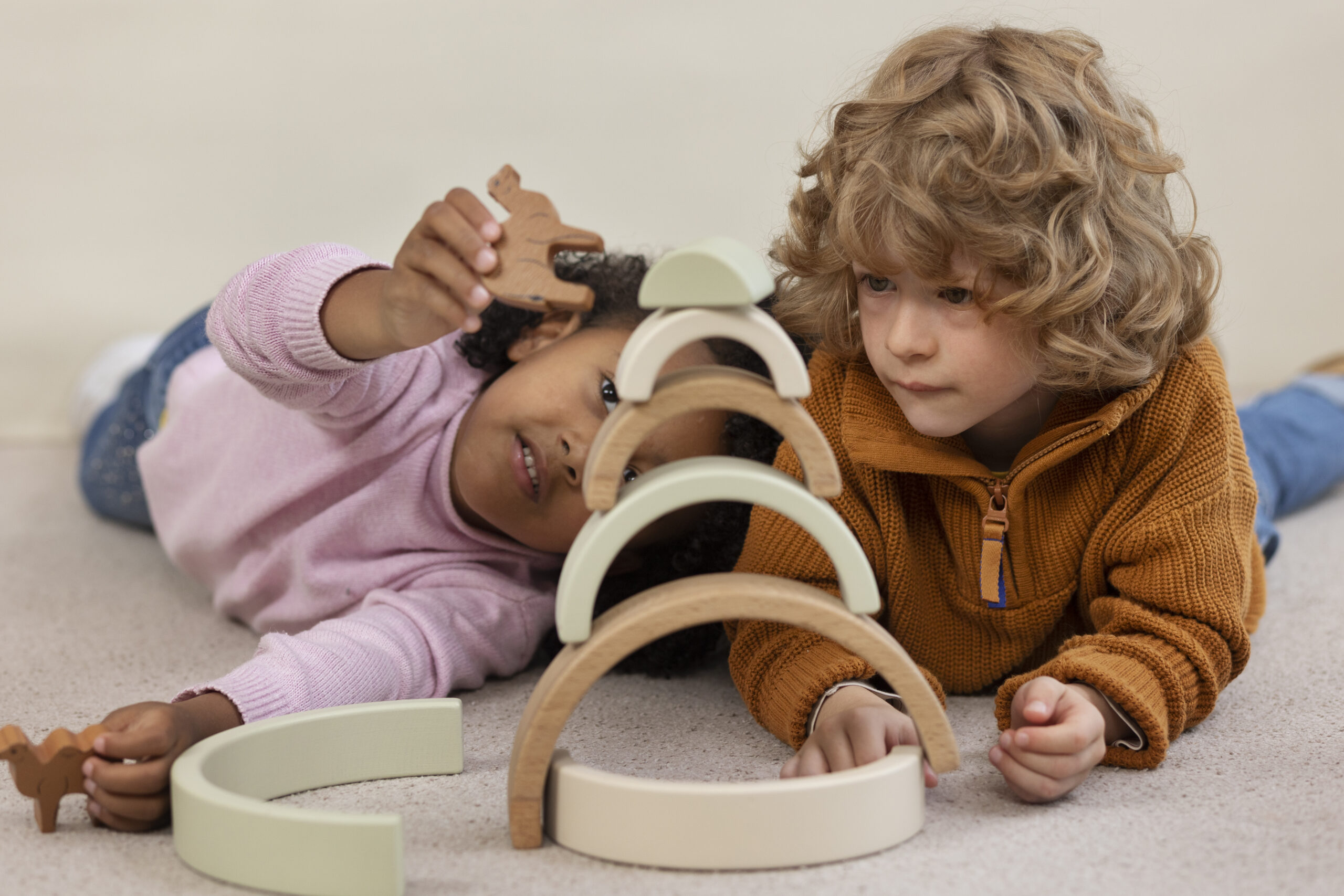 Happy Kids Boutique kinderen spelen samen met houten speelgoed en bouwen een toren met bogen, creatief spel met oog voor duurzaamheid