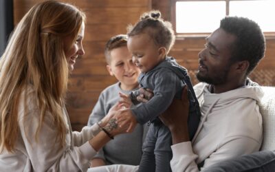Happy Kids Boutique diversiteit gezin waarin ouders en kinderen samen spelen en lachen in een warme huiselijke setting, zichtbaar verschillende achtergronden en cultuurverschillen met aandacht voor duurzaamheid