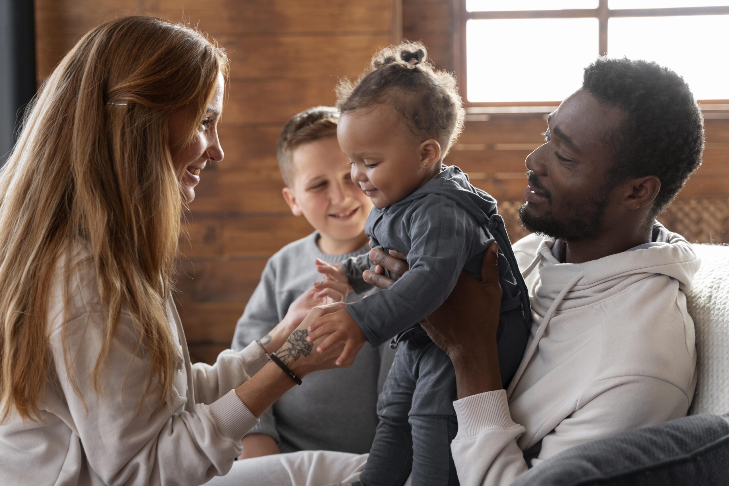 Happy Kids Boutique diversiteit gezin waarin ouders en kinderen samen spelen en lachen in een warme huiselijke setting, zichtbaar verschillende achtergronden en cultuurverschillen met aandacht voor duurzaamheid