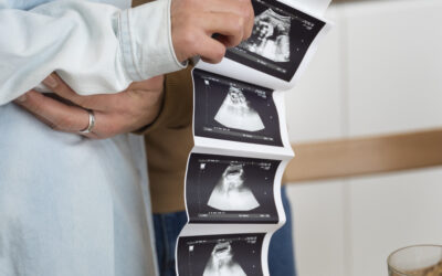 Happy Kids Boutique baby en zwanger moment waarbij aanstaande ouders een echo foto vasthouden en bekijken, liefdevolle situatie die past bij een zwangerschap aankondigen in huiselijke omgeving