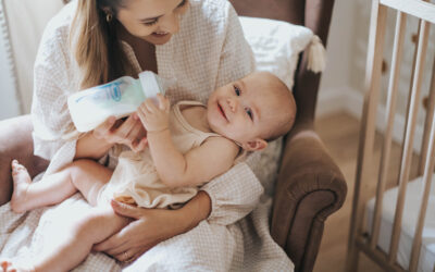 Blogfoto flesvoeding Happy Kids Boutique moeder geeft flesvoeding aan baby met Dr. Brown's babyfles, baby ligt ontspannen op schoot tijdens het voeden in een rustige babykamer
