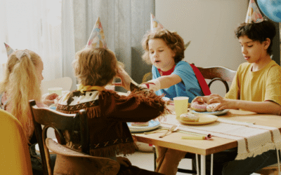 Kinderen vieren samen een gezellig kinderfeestje met feesthoedjes, lekkernijtjes en ballonnen.