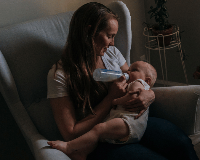 blogfoto nachtvoeding baby Moeder geeft haar baby ’s nachts de fles tijdens een rustig voedingsmoment.
