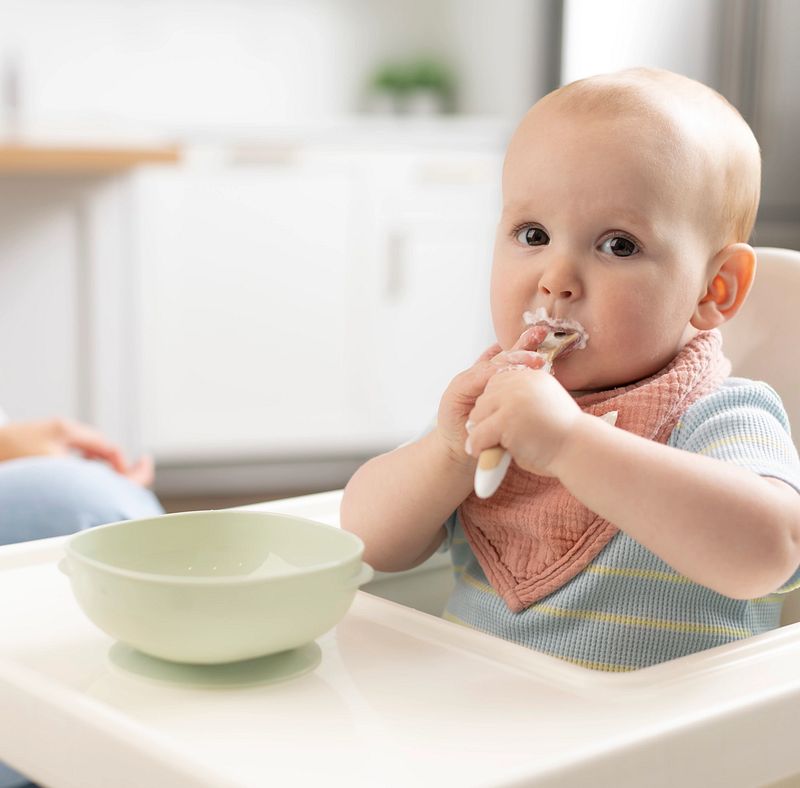 Baby eet zelfstandig uit een Dr. Brown’s antislip kommetje met zuignap aan tafel