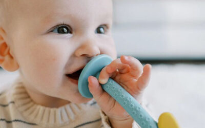 Baby bijt op blauw bijtspeelgoed en bijtring om het tandvlees te verzachten.